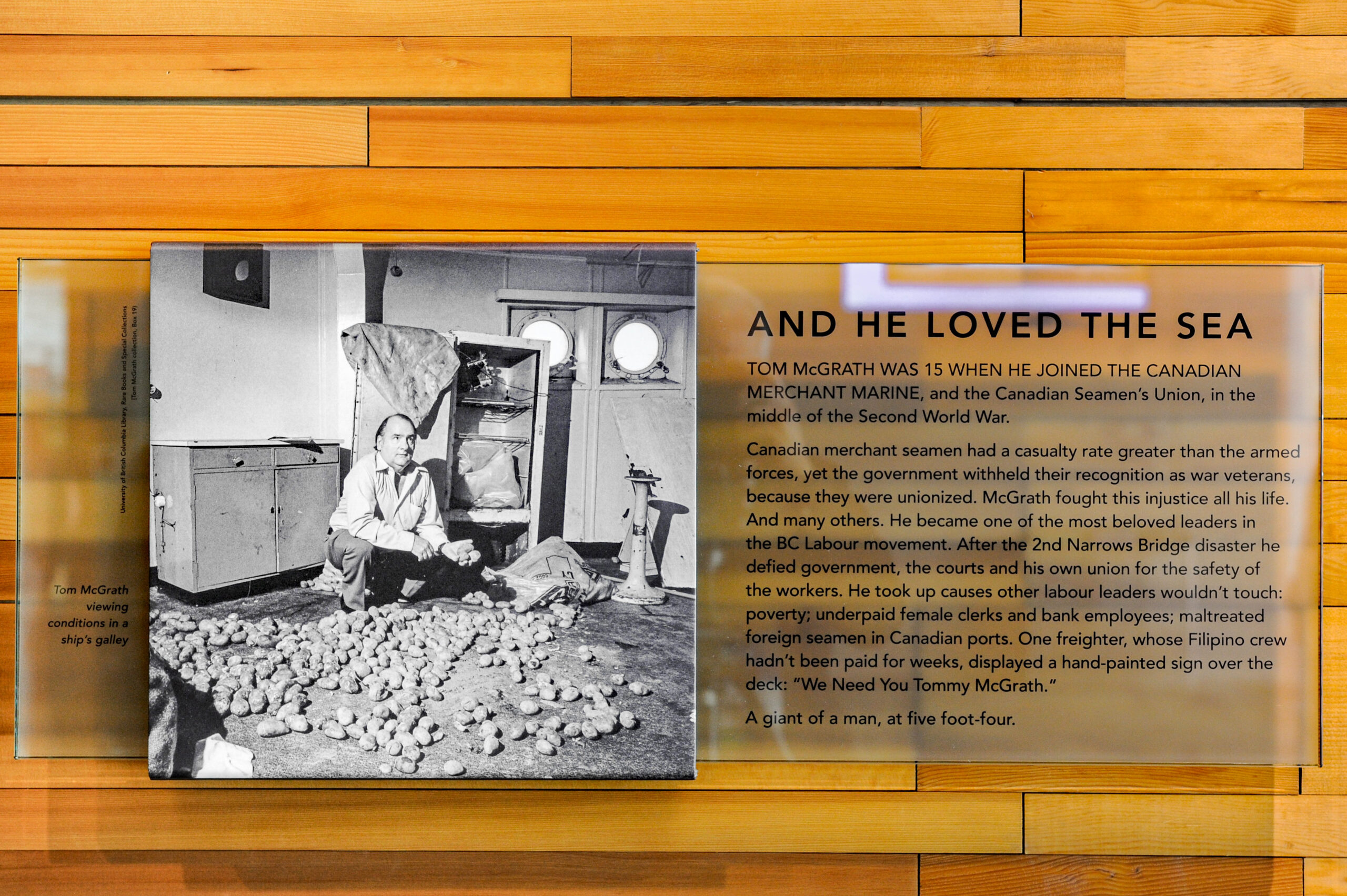 The plaque reads: Tom McGrath was 15 when he joined the Canadian Merchant Marine and the Canadian Seamen's Union in the middle of the Second World War. Canadian merchant seamen had a casualty rate greater than the armed forces, yet the government withheld their recognition as war veterans, because they were unionised. McGrath fought this injustice all his life, and many others. He became one of the most beloved leaders in the BC Labour movement. After the Second Narrows Bridge disaster, he defied government, the courts and his own union for the safety of the workers. He took up causes other labour leaders wouldn't touch: poverty; underpaid female clerks and bank employees; maltreated foreign seamen in Canadian ports. One freighter, whose Filipino crew hadn't been paid for weeks, displayed a hand-painted sign over the deck: “We need you, Tom McGrath.” A giant of a man, at five-foot-four.
