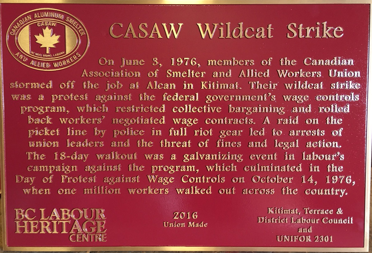 The plaque reads: On June 3, 1976, members of the Canadian Association of Smelter and Allied Workers Union stormed off the job at Alcan in Kitimat. Their wildcat strike was a protest against the federal government’s wage controls program, which restricted collective bargaining and rolled back workers’ negotiated wage contracts. A raid on the picket line by police in full riot gear led to arrests of union leaders and the threat of fines and legal action. The 18-day walkout was a galvanizing event in labour’s campaign against the program, which culminated in the Day of Protest against Wage Controls on October 14, 1976, when one million workers walked out across the country. BC Labour Heritage Centre 2016 Union Made Kitimat, Terrace & District Labour Council and UNIFOR 2301