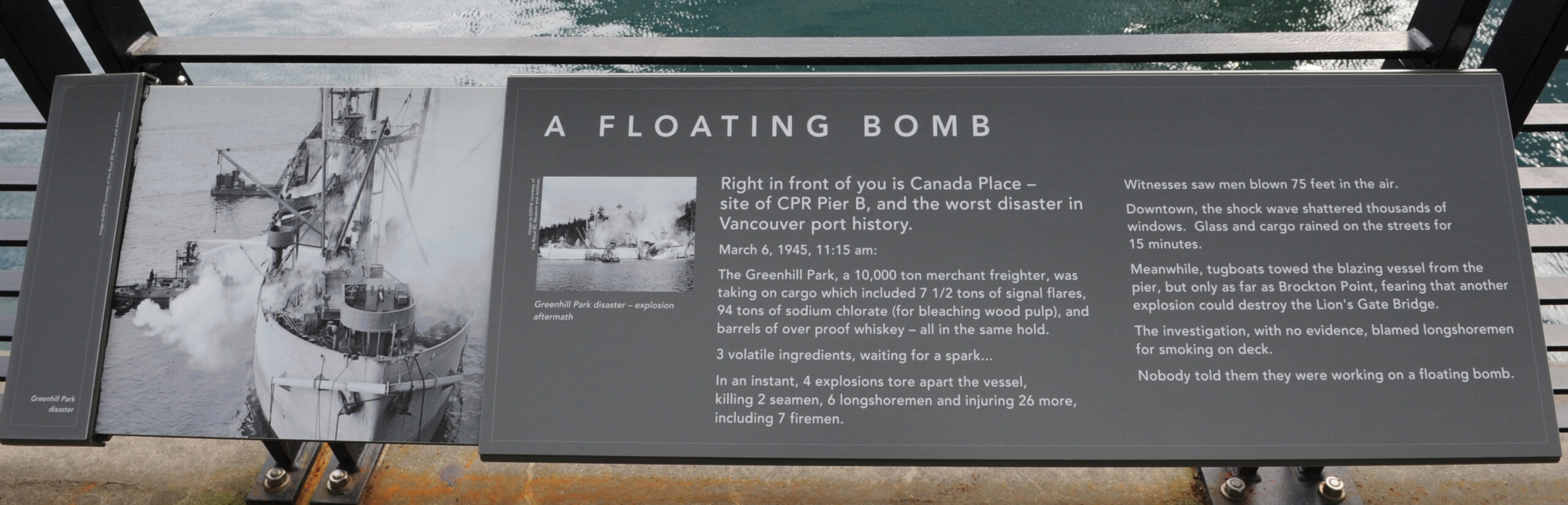 The plaque reads: Right in front of you is Canada Place – site of CPR Pier B, and the worst disaster in Vancouver port history. March 6, 1945, 11:15 am: The Greenhill Park, a 10,000 ton merchant freighter, was taking on cargo which included 7 1/2 tons of signal flares, 94 tons of sodium chlorate (for bleaching wood pulp), and barrels of over proof whiskey – all in the same hold. 3 volatile ingredients, waiting for a spark… In an instant, 4 explosions tore apart the vessel, killing 2 seamen, 6 longshoremen and injuring 26 more, including 7 firemen. Witnesses saw men blown 75 feet in the air. Downtown, the shock wave shattered thousands of windows. Glass and cargo rained on the streets for 15 minutes. Meanwhile, tugboats towed the blazing vessel from the pier, but only as far as Brockton Point, fearing that another explosion could destroy the Lion’s Gate Bridge. The investigation, with no evidence, blamed longshoremen for smoking on deck. Nobody told them they were working on a floating bomb.
