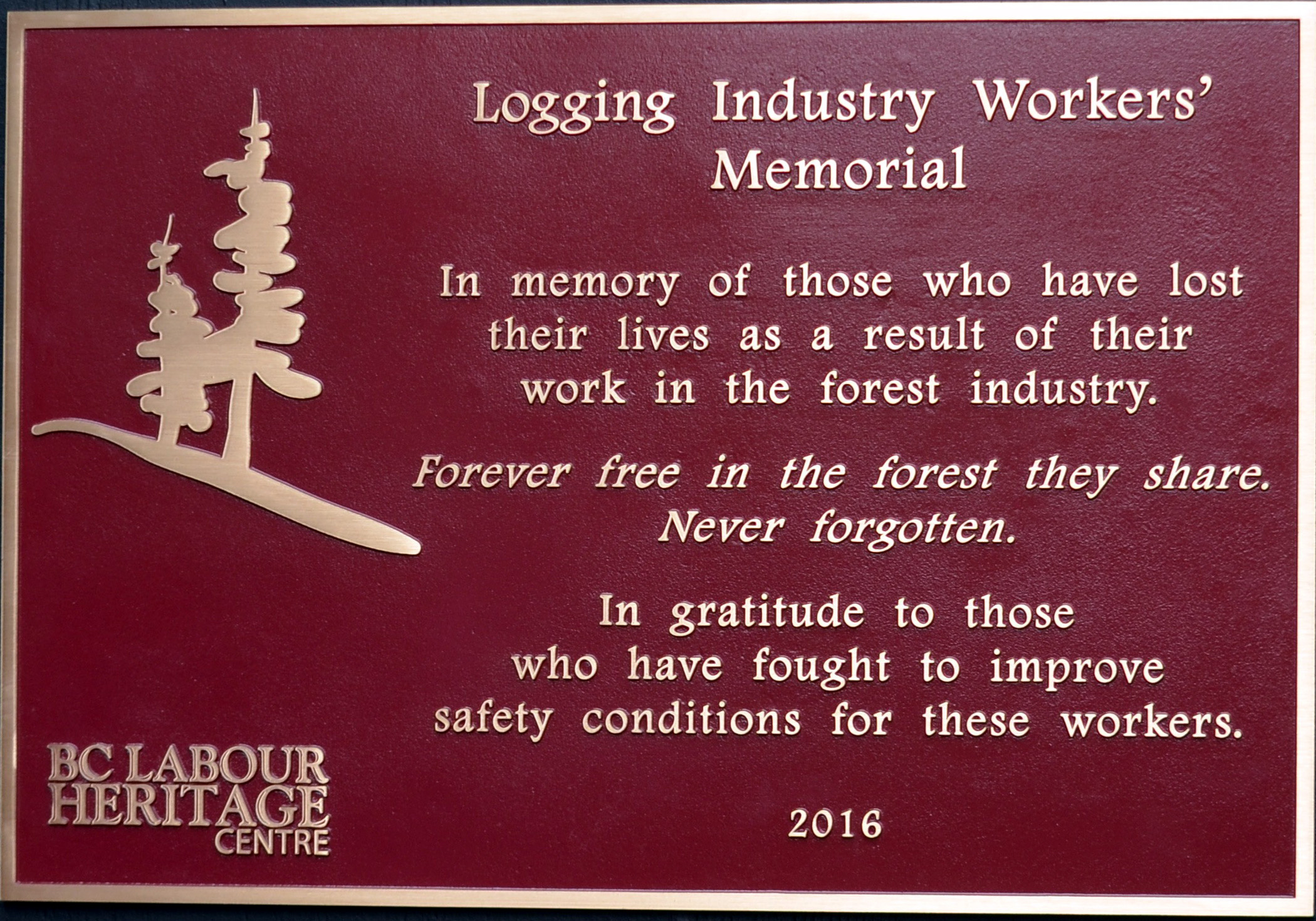 The plaque reads: In memory of those who have lost their lives as a result of their work in the forest industry. Forever free in the forest they share. Never forgotten. In gratitude to those who have fought to improve safety conditions for these workers. BC Labour Heritage Centre 2016