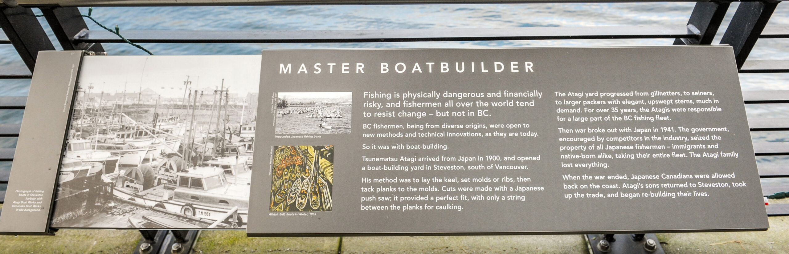 The plaque reads: Fishing is physically dangerous and financially risky, and fishermen all over the world tend to resist change – but not in BC. BC fishermen, being from diverse origins, were open to new methods and technical innovations, as they are today. So it was with boat-building. Tsunematsu Atagi arrived from Japan in 1900, and opened a boat-building yard in Steveston, south of Vancouver. His method was to lay the keel, set molds or ribs, then tack planks to the molds. Cuts were made with a Japanese push saw; it provided a perfect fit, with only a string between the planks for caulking. The Atagi yard progressed from gillnetters, to seiners, to larger packers with elegant, upswept sterns, much in demand. For over 35 years, the Atagis were responsible for a large part of the BC fishing fleet. Then war broke out with Japan in 1941. The government, encouraged by competitors in the industry, seized the property of all Japanese fishermen – immigrants and native-born alike, taking their entire fleet. The Atagi family lost everything. When the war ended, Japanese Canadians were allowed back on the coast. Atagi’s sons returned to Steveston, took up the trade, and began re-building their lives.