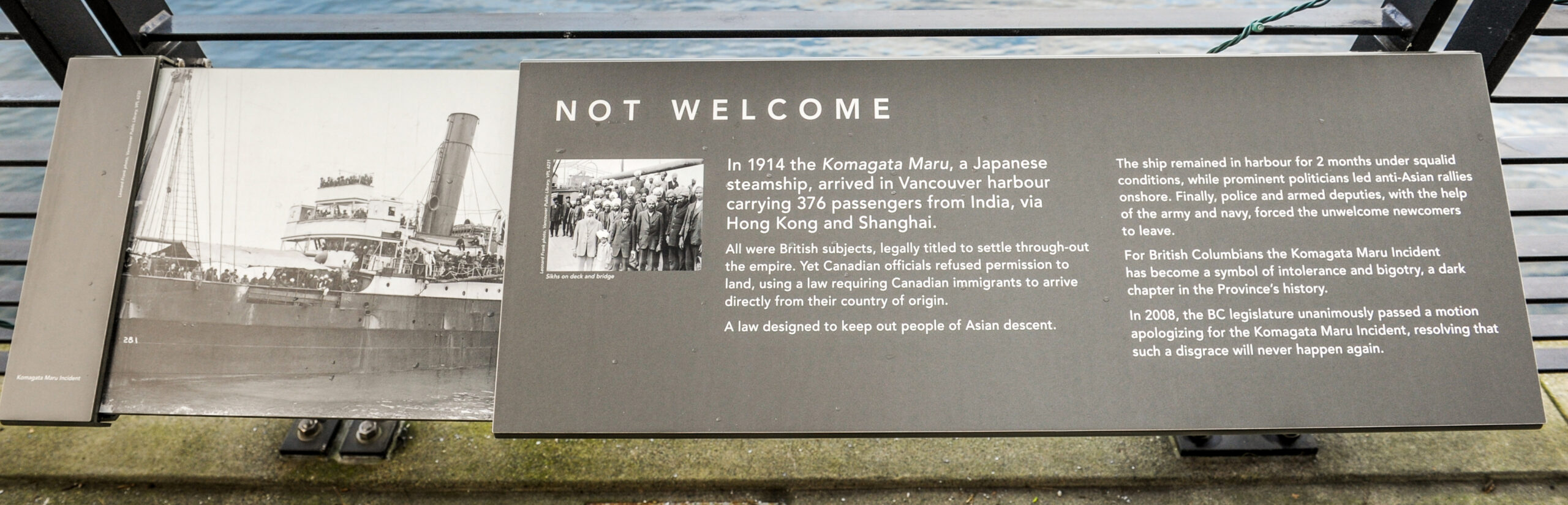 The plaque reads: In 1914 the Komagata Maru, a Japanese steamship, arrived in Vancouver harbour carrying 376 passengers from India, via Hong Kong and Shanghai. All were British subjects, legally titled to settle throughout the empire. Yet Canadian officials refused permission to land, using a law requiring Canadian immigrants to arrive directly from their country of origin. A law designed to keep out people of Asian descent. The ship remained in harbour for two months under squalid conditions, while prominent politicians led anti-Asian rallies onshore. Finally, police and armed deputies, with the help of the army and navy, forced the unwelcome newcomers to leave. For British Columbians the Komagata Maru Incident has become a symbol of intolerance and bigotry, a dark chapter in the Province’s history. In 2008, the BC legislature unanimously passed a motion apologizing for the Komagata Maru Incident, resolving that such a disgrace will never happen again.
