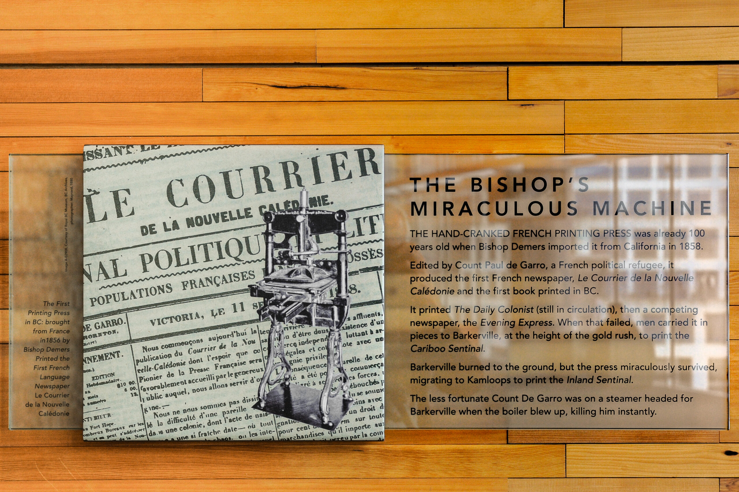 The plaque reads: The hand-cranked French printing press was already 100 years old when Bishop Demers imported it from California in 1858. Edited by Count Paul de Garro, a French political refugee, it produced the first French newspaper, Le Courrier de la Nouvelle Calédonie, and the first book printed in B.C. It printed the Daily Colonist (still in circulation), then a competing newspaper, the Evening Express. When that failed, men carried it in pieces to Bakerville, at the height of the gold rush, to print the Caribou Sentinel. Bakerville burned to the ground, but the press miraculously survived, migrating to Kamloops to print the Inland Sentinel. The less fortunate Count de Gareau was on a steamer headed for Bakerville when the boiler blew up, killing him instantly.
