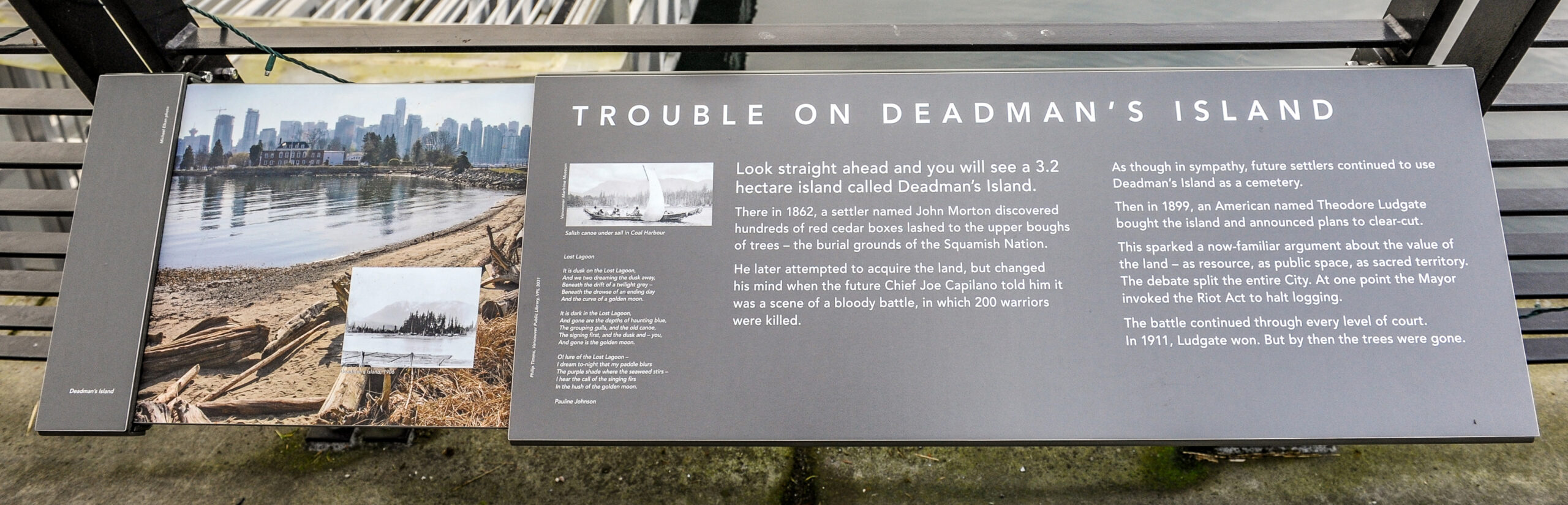 The plaque reads: Look straight ahead and you will see a 3.2 hectare island called Deadman’s Island. There in 1862, a settler named John Morton discovered hundreds of red cedar boxes lashed to the upper boughs of trees – the burial grounds of the Squamish Nation. He later attempted to acquire the land, but changed his mind when the future Chief Joe Capilano told him it was a scene of a bloody battle, in which 200 warriors were killed. As though in sympathy, future settlers continued to use Deadman’s Island as a cemetery. Then in 1899, an American named Theodore Ludgate bought the island and announced plans to clear-cut. This sparked a now-familiar argument about the value of the land – as resource, as public space, as sacred territory. The debate split the entire City. At one point the Mayor invoked the Riot Act to halt logging. The battle continued through every level of court. In 1911, Ludgate won. But by then the trees were gone.