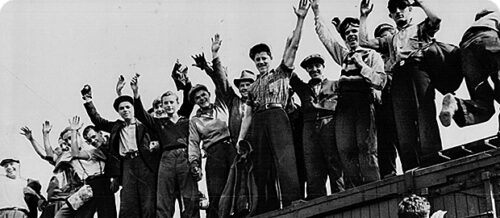 A group of men protesting on top of a building/shed
