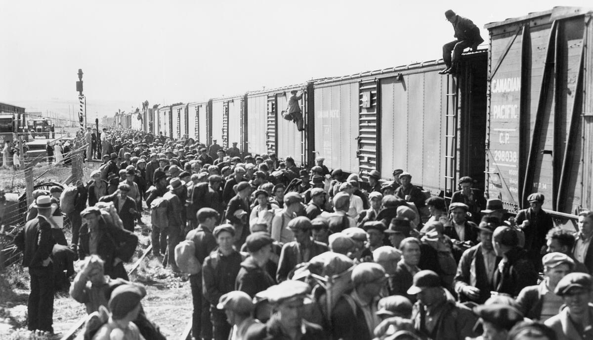 Black and white photo of a group of men standing by the train